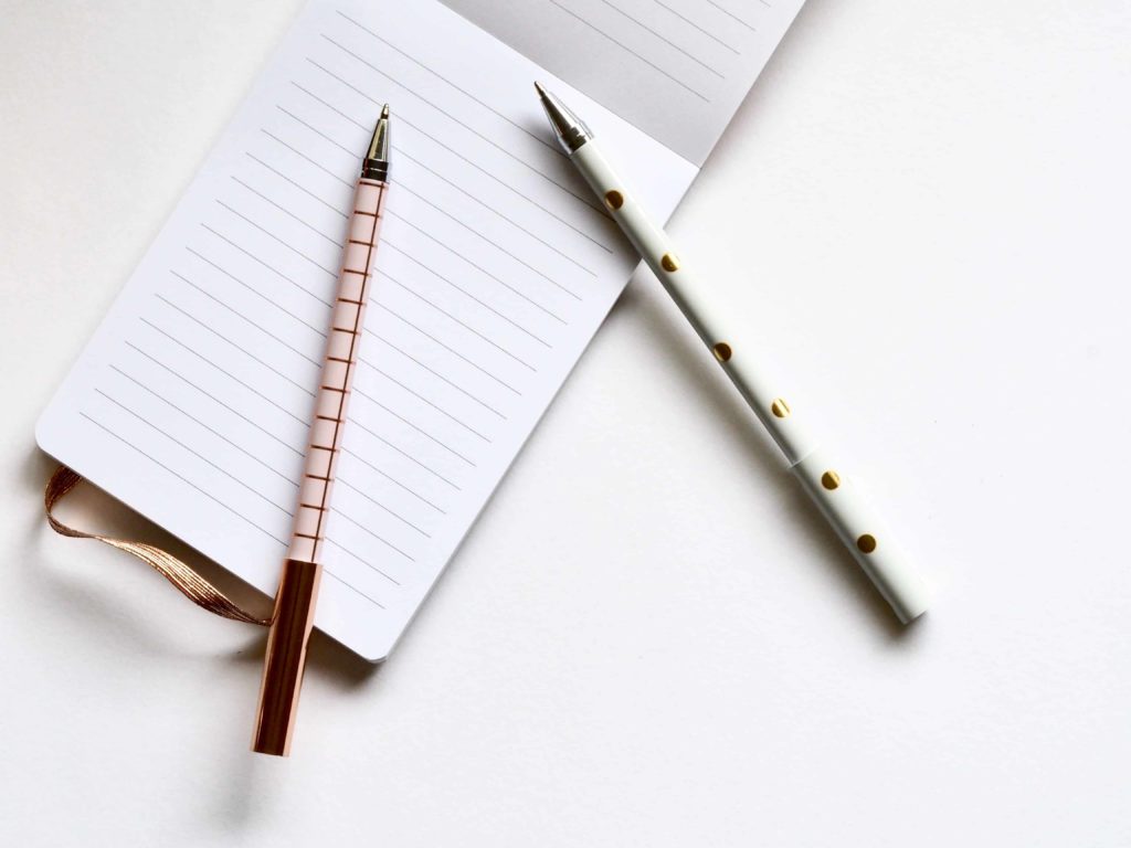 Image with two pens and blank notepad, downloaded from Unsplash, used as part of the article on Grade 11 previous exam papers, free pdf downloads for examination preparation and revision